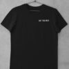 Das Bild zeigt ein schwarzes T-Shirt mit Eat The Rich Design (gestickt). Das T-Shirt ist auf einem Kleiderhaken aufgehängt. Es wird verwendet, um einen Eindruck zu vermitteln, wie das reale Produkt letztendlich aussehen wird.
