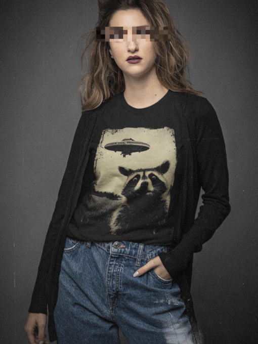 Das Bild zeigt eine Frau die das schwarze T-Shirt mit dem Waschbär trägt. Es wird verwendet, um einen Eindruck zu vermitteln, wie das Produkt an einem Menschen aussieht.
