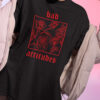 Nahaufnahme von Unisex Relaxed Fit T-Shirt mit Bad Attitudes Rosen Design.