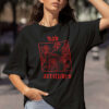 Frau trägt schwarzes Unisex Relaxed Fit T-Shirt mit Bad Attitudes Rosen Design.