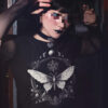 Gothic Girl trägt schwarzes T-Shirt mit Motten Pentagram Design.